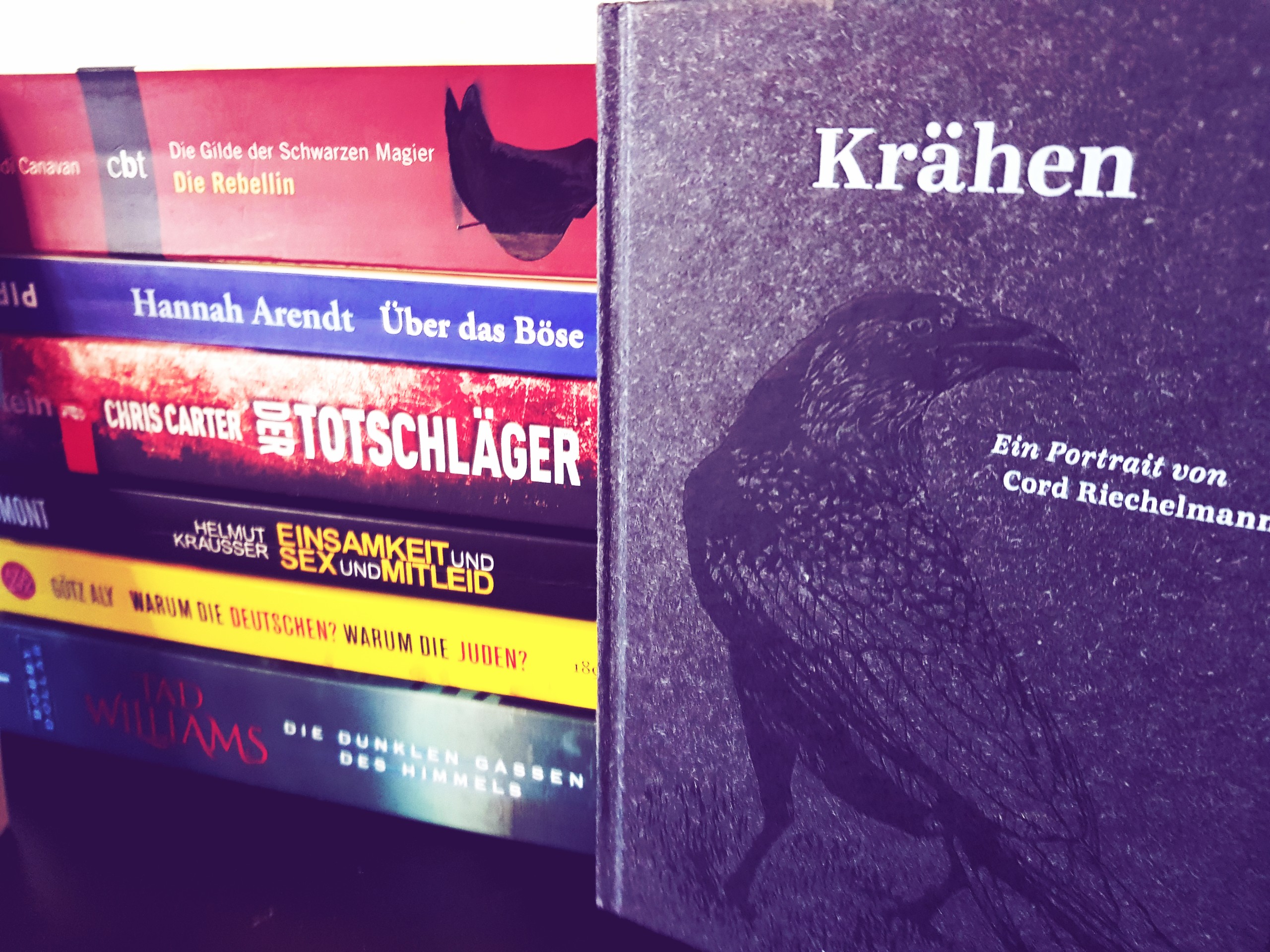 Buchstapel, im Vordergrund ein Buch über Krähen