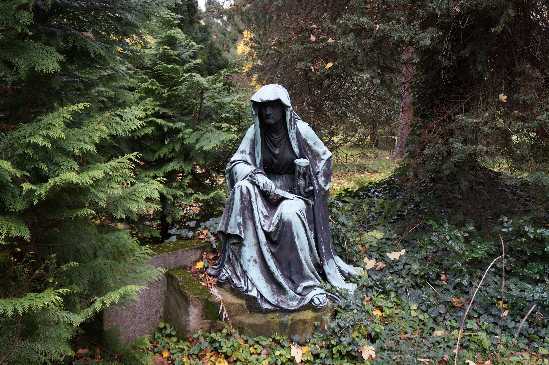 Kupferstatue mit Sanduhr im Wald